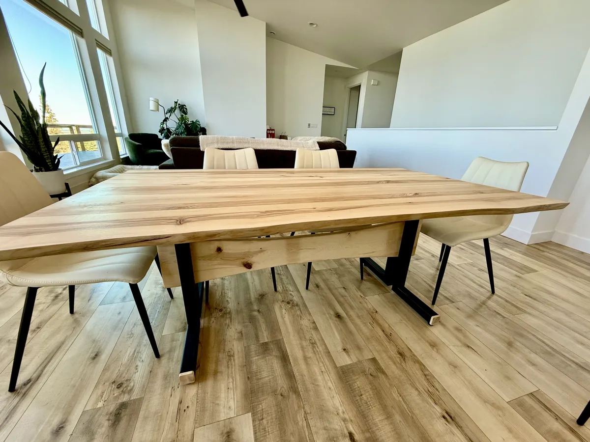 Light birch dining table in modern open-plan Alaska home with forest views